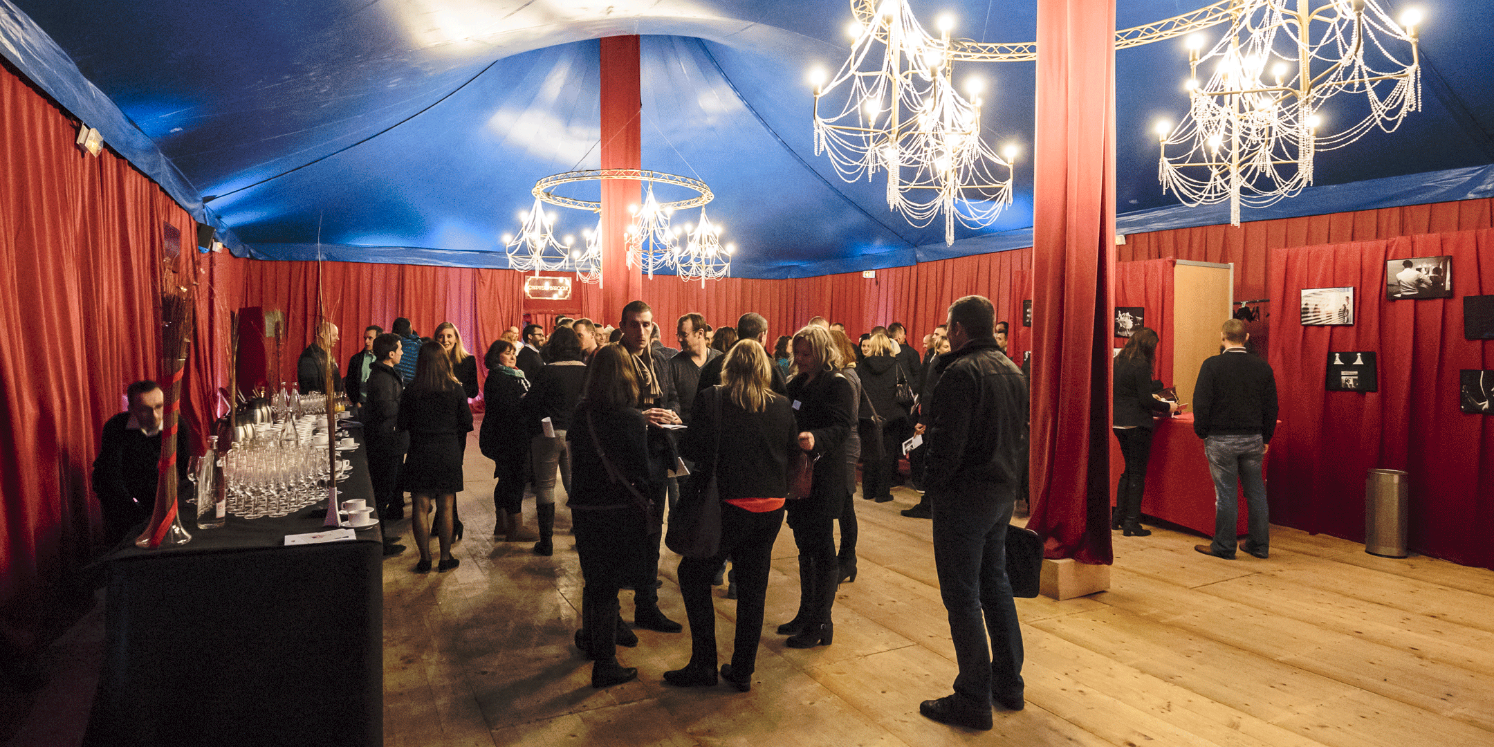Employés de l'entreprise SNCF se réunissant sous un chapiteau rouge et bleu pour un séminaire d'entreprise