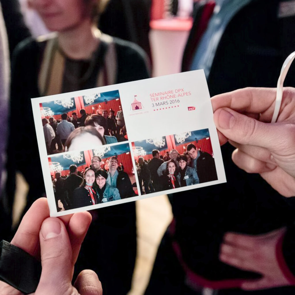 Personne tenant des photographies souvenir de la journée d'atelier au cirque de la SNCF