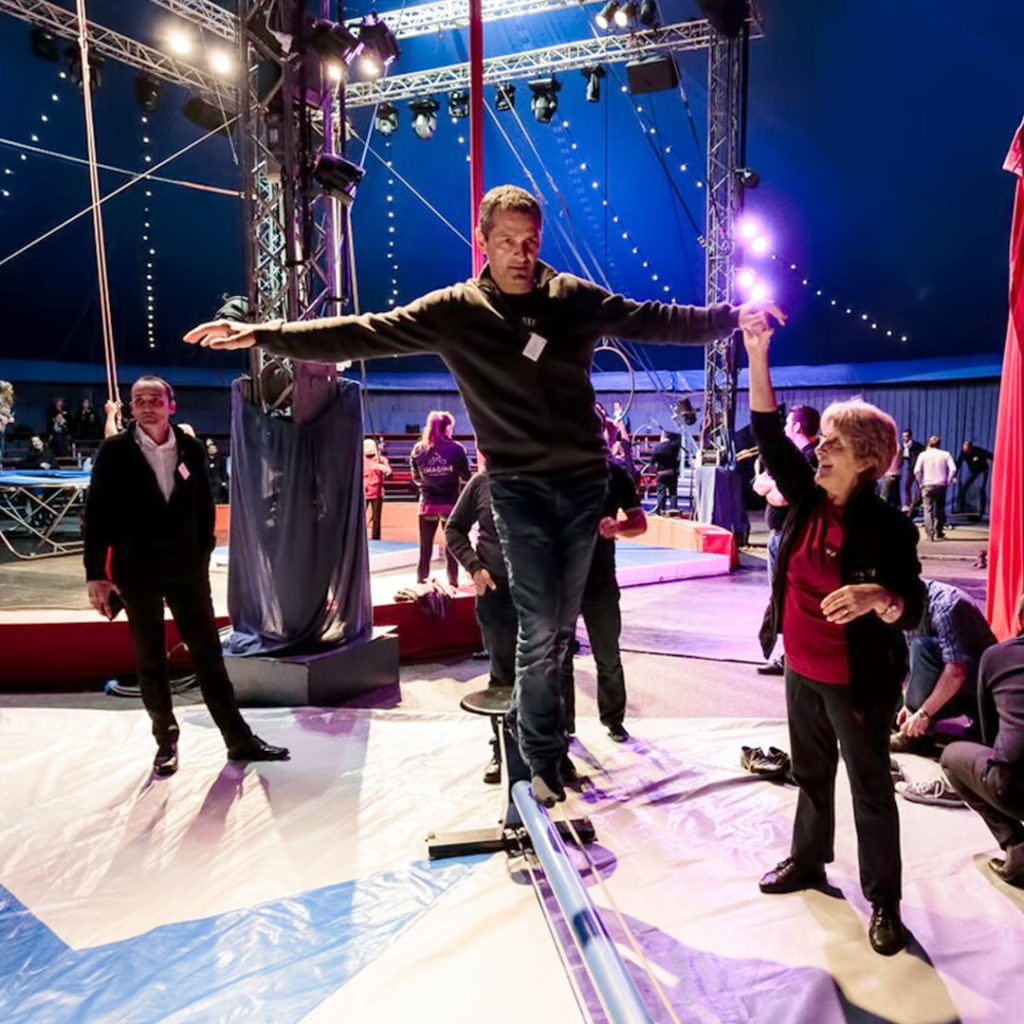 Homme qui apprend à tenir en équilibre sur une poutre au milieu d'un chapiteau de cirque