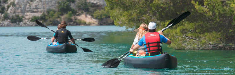 Deux kayak naviguant de dos sur une eau calme