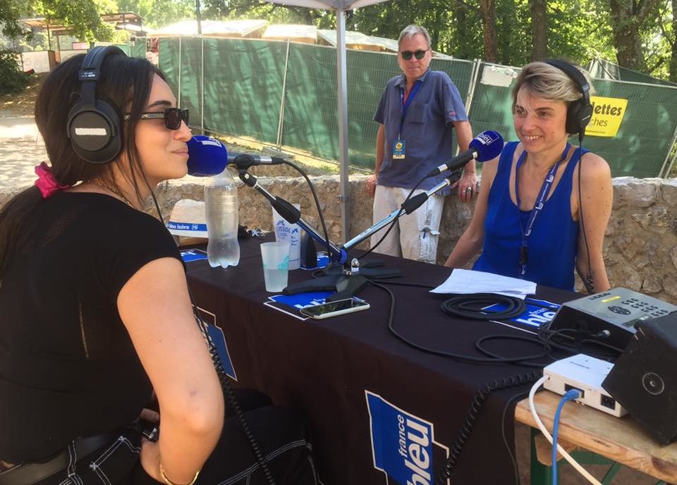 Photographie de deux personnes dont Camelia Jordana autours de micro de la radio france bleu