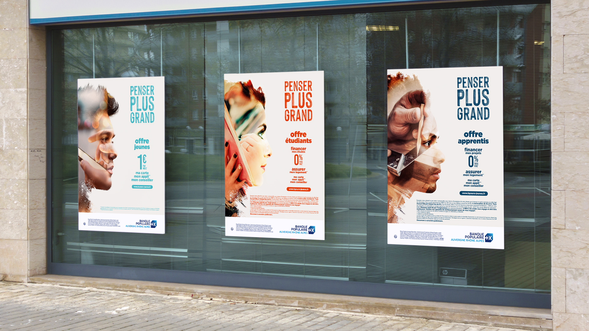 Trois affiches bleu turquoise, orange et bleu marine affichées sur les murs de la banque pour la campagne de communication jeune 2020