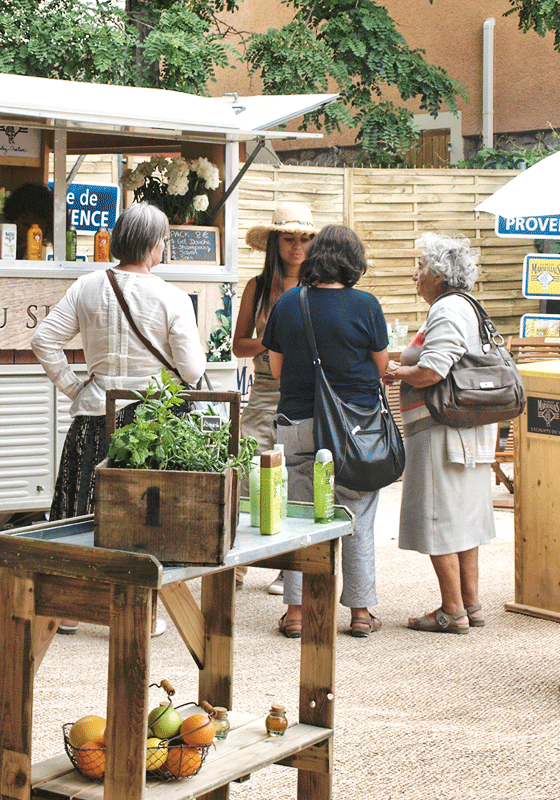 Femmes au milieu du stand marketing Petit Marseillais qui discutent de la nouvelle gamme de produit de la marque avec une animatrice commerciale