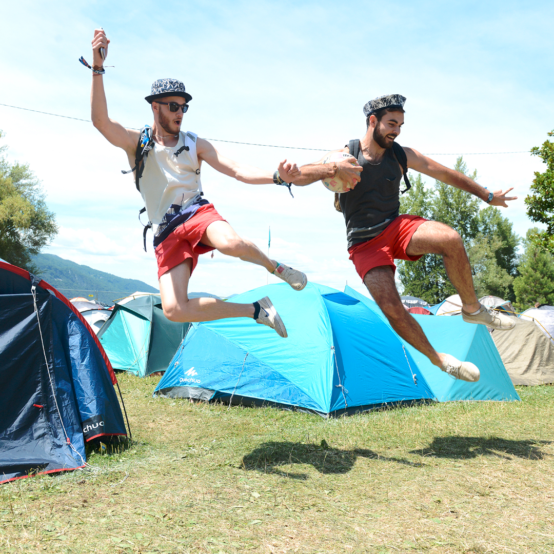 Duo d'homme en train de sauter en l'aire au milieu du camping du festival Musilac