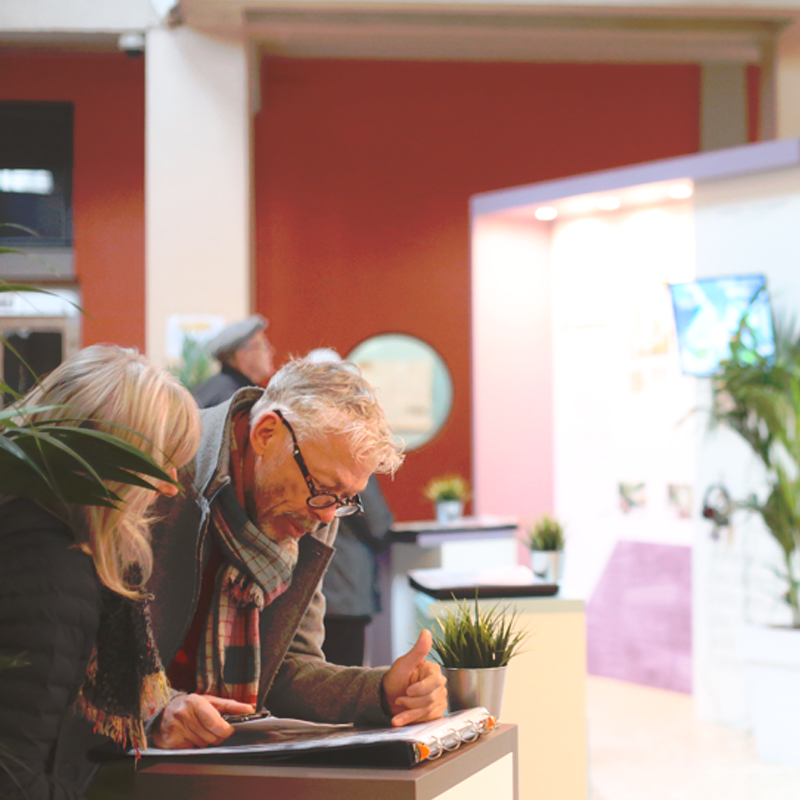 Photographie avec personnes dans le hall des Thermes d'aix les bains devant des panneaux de présentation du projet de réhabilitation